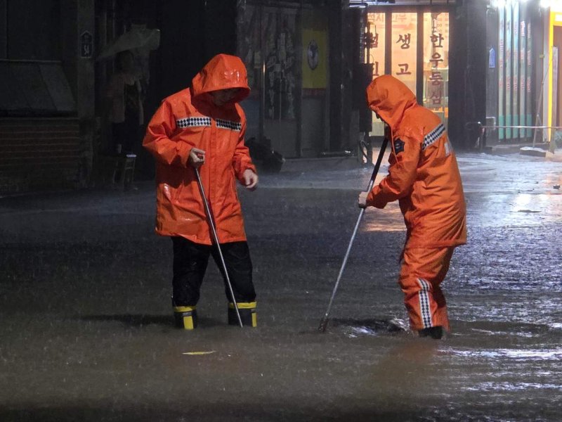 [광주=뉴시스] 광주지역에 폭우가 쏟아진 3일 오후 광주 북구 운암동에서 주민들이 침수 피해를 막기 위해 주변 쓰레기를 정리하고 있다. (사진 = 독자 제공) 2025.08.03. photo@newsis.com