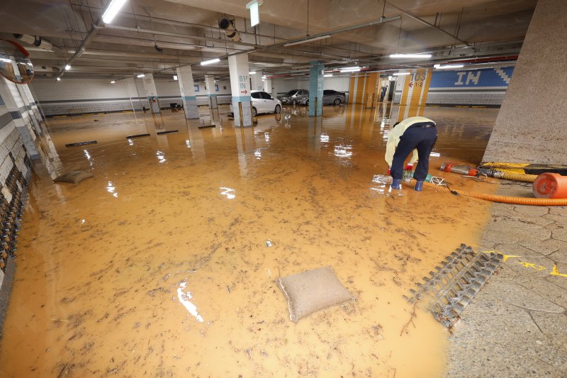 4일 전남 무안군 무안읍 한 아파트 주차장이 폭우에 침수돼 주민들이 흙탕물을 퍼내고 있다. 2025.8.4/뉴스1 ⓒ News1 김태성 기자