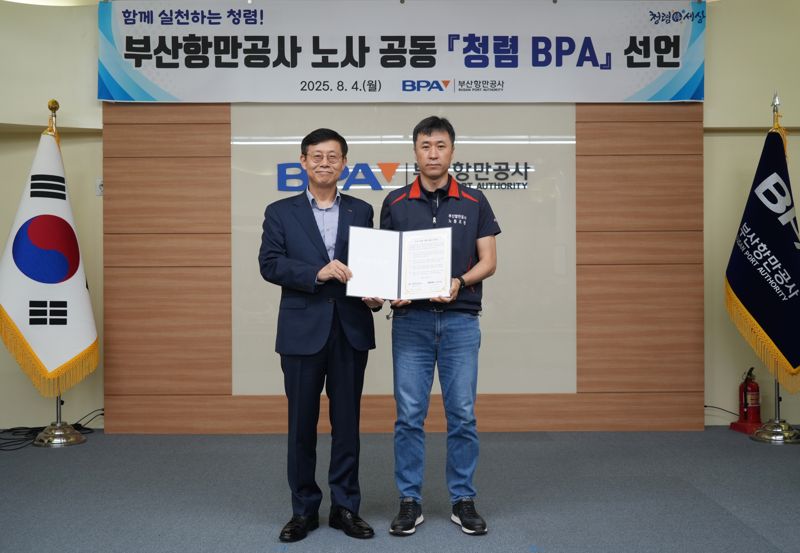 부산항만공사 송상근 사장(왼쪽)과 박신호 노조위원장이 토토 바카라 사이트문을 들고 기념사진을 촬영하고 있다. 부산항만공사 제공