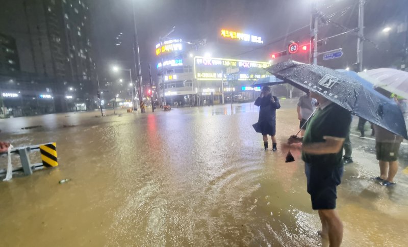 호우경보가 내린 3일 오후 광주 북구 운암동 신안교 일대 도로가 침수돼 북구청 공무원들이 현장을 점검하고 있다. (독자 제공. 재판매 및 DB 금지) 2025.8.3/뉴스1 ⓒ News1 박준배 기자