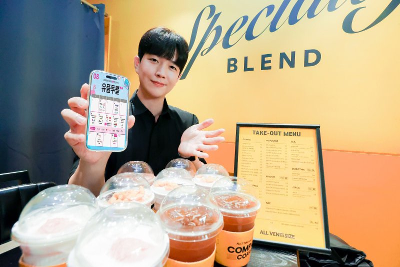 유플투쁠 인기 혜택인 컴포즈커피 매장에서 LG유플러스 직원이 8월 혜택을 소개하고 있다. LG유플러스 제공