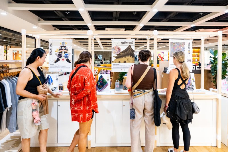 서울마이소울샵 세종문화회관점에서 신규 아트콜라보 상품을 구경하는 외국인 방문객들(서울관광재단 제공)