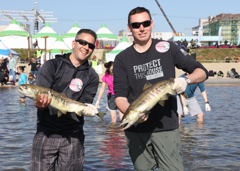 강원도 양양군 남대천 일원에서 열린 ‘2018양양연어축제’에서 연어맨손잡기 체험에 참가한 외국인 관광객들이 직접 잡은 연어를 들어 보이고 있다.(자료사진) (양양군 제공) 2018.10.21/뉴스1 ⓒ News1 고재교 기자