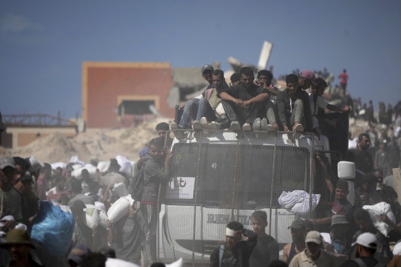 [베이트 라히야=AP/뉴시스] 1일(현지 시간) 가자지구 북부 베이트 라히야 외곽에서 팔레스타인 주민들이 가자시티로 향하던 인도적 물품 수송 트럭에서 내린 밀가루 자루를 나르고 있다. 2025.08.02.