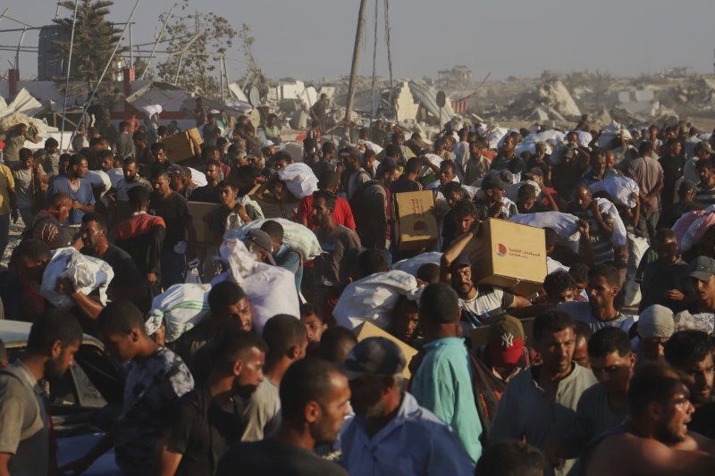 [라파=AP/뉴시스] 4일(현지 시간) 가자지구 남부 라파 인근에서 팔레스타인 주민들이 모라그 회랑을 따라 이동하는 인도주의 구호 물품 수송 트럭에서 가져온 구호 물품을 옮기고 있다. 2025.08.05.