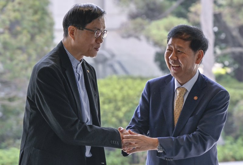 구윤철 경제부총리 겸 기획재정부 장관(오른쪽)이 7일 오전 서울시 중구 남대문로 한국은행을 방문, 마중 나온 이창용 한국은행 총재와 손을 맞잡은 뒤 환하게 미소 짓고 있다. 뉴스1