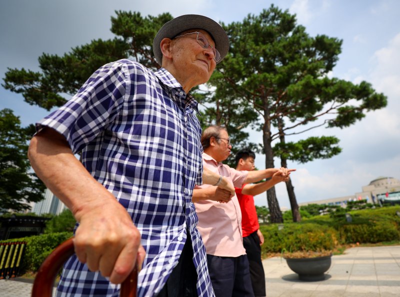 비전향장기수 안학섭씨가 지난 8일 서울 용산구 대통령집무실 앞에서 열린 송환촉구 기자회견에서 사위 이적 목사와 함께 전쟁기념관 앞을 지나고 있다. 연합뉴스