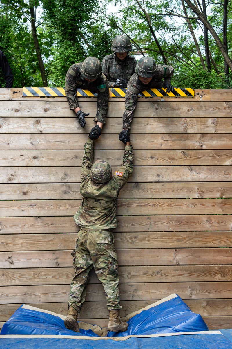 육군이 지난 7일부터 8일 충북 괴산 육군학생군사학교에서 '한미 ROTC 사관후보생 동반훈련'을 실시했다고 8일 밝혔다. 사진은 양국의 후보생들이 힘을 모아 담장을 넘어가고 있는 모습. 육군 제공