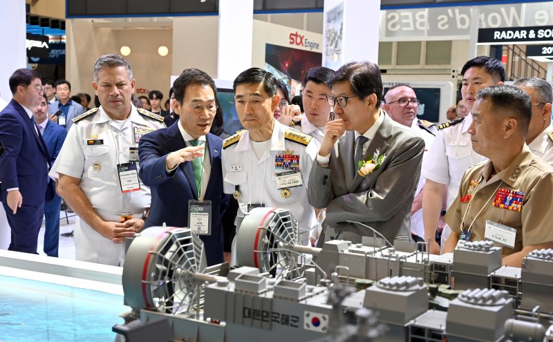 유상철 HJ중공업 대표(앞줄 오른쪽 네번째)가 지난 5월 부산 벡스코에서 열린 '2025 국제해양방위산업전(MADEX)'에서 주요 국가 사절단을 대상으로 고속상륙정에 대해 설명하고 있다. HJ중공업 제공