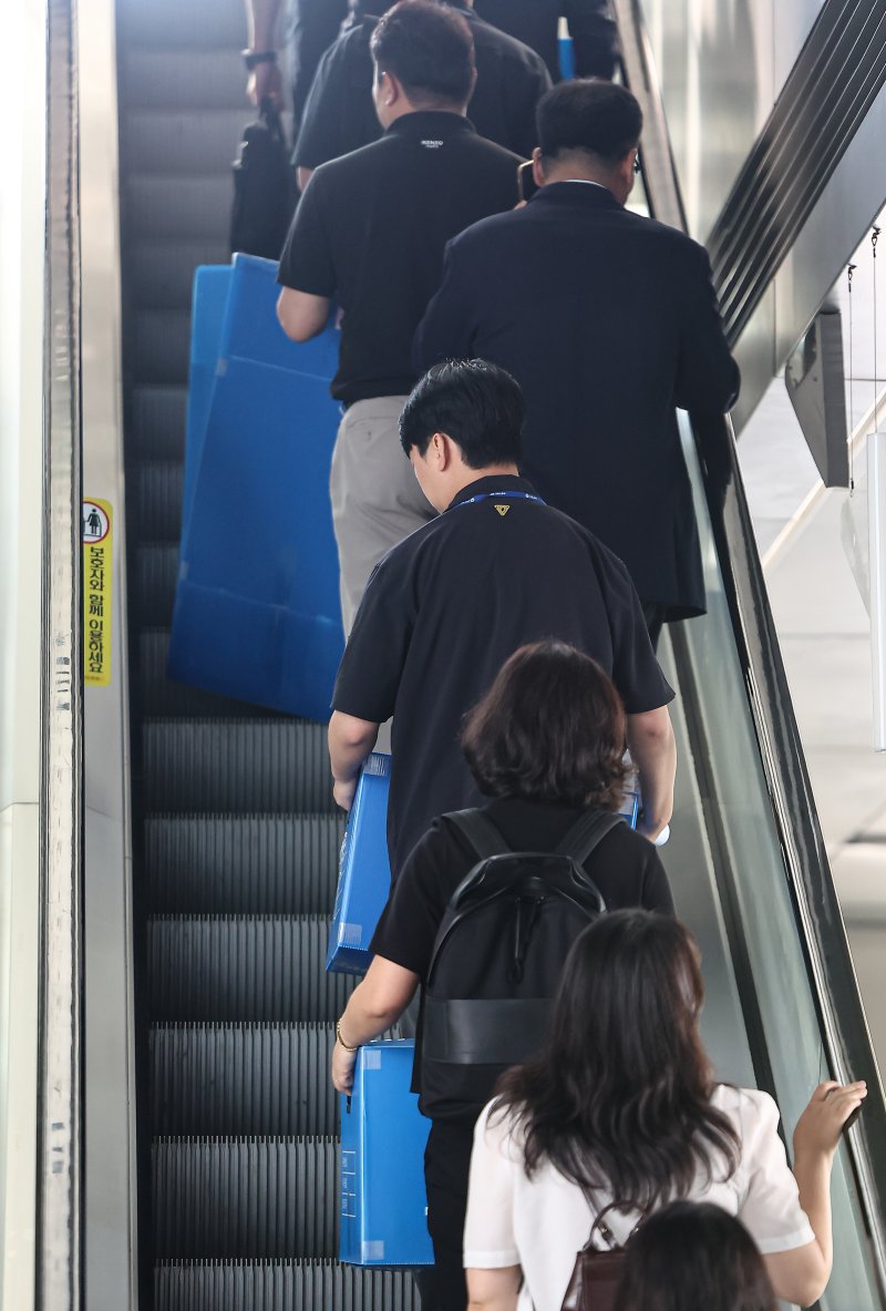 경기남부경찰청과 고용노동부 관계자들이 12일 인천시 연수구 포스코이앤씨 본사 사옥에서 압수품을 담기 위한 박스를 들고 이동하고 있다. 2025.8.12/뉴스1 ⓒ News1 김도우 기자