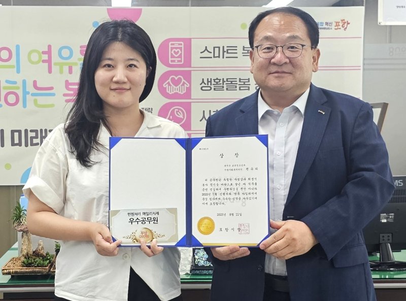 [포항=뉴시스] 송종욱 기자 = 포항시는 7월 '민원 처리 단축 마일리지' 우수 공무원에 편유리 주무관을 선정해 시상했다. 사진은 지난 11일 편준 시 복지국장(오른쪽)이 편 주무관에게 상을 준 후 격려하는 모습. (사진=포항시 제공) 2025.08.12. photo@newsis.com
