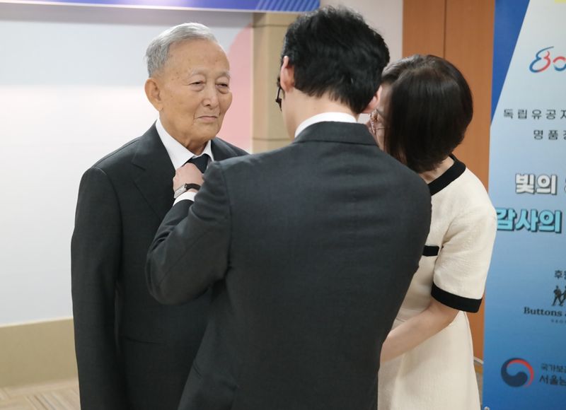 13일 오전 서울 방배동 서울남부보훈지청 유일한홀에서 열린 정장 증정식에서 윤봉길 의사 조카 윤택 어르신(왼쪽)이 옷매무새를 가다듬고 있다. 사진=김경수 기자