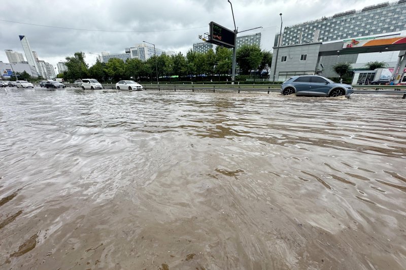 [고양=뉴시스] 홍효식 기자 = 서울을 비롯한 수도권에 호우주의보가 내린 13일 경기 고양시 통일로에서 차량들이 침수된 거리를 빠져 나가고 있다. 2025.08.13. yesphoto@newsis.com