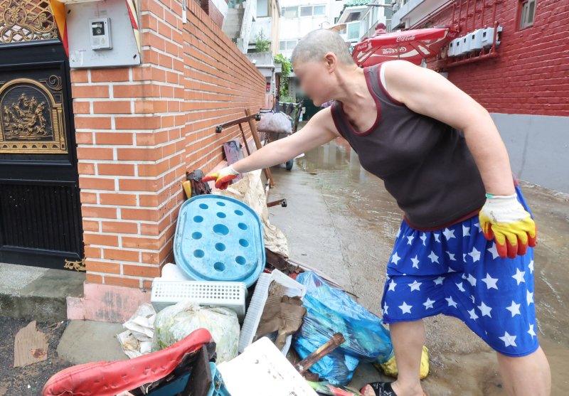 [인천=뉴시스] 전진환 기자 = 간밤에 내린 폭우로 인천 서구 석남동 저지대 주택가가 침수된 가운데 13일 오전 물이 빠진 후 한 입주민이 물이 차올랐던 높이를 가리키고 있다. 2025.08.13. amin2@newsis.com