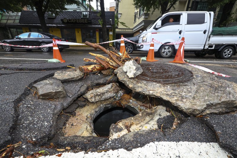 [서울=뉴시스] 황준선 기자 = 서울에 많은 비가 내린 13일 서울 종로구 한 도로가 파손돼 주변이 통제되고 있다. 2025.08.13. hwang@newsis.com