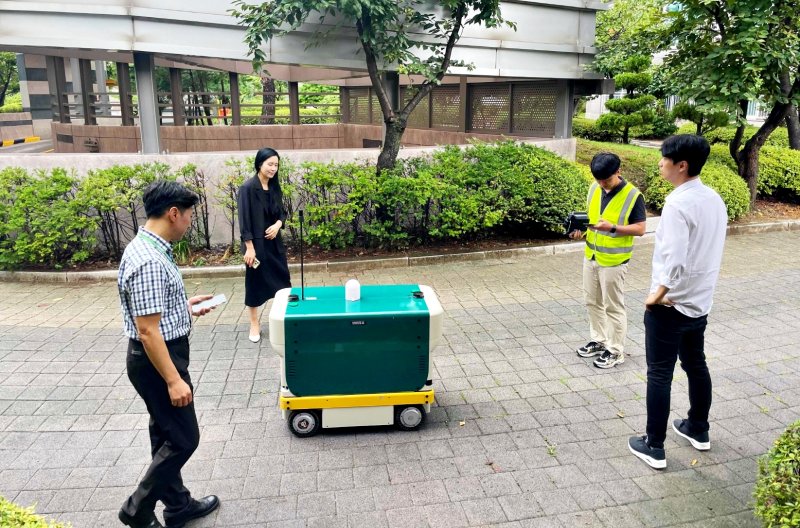 [수원=뉴시스] 경기 수원시 관계자들이 광교지역 아파트단지에서 자율주행 메이저 바카라사이트 주사위 '로바'의 방범 기능을 점검하고 있다. 로봇은 지능형 폐쇄회로(CC)TV를 탑재해 위험 상황을 실시간으로 감지한다. (사진=수원시 제공) 2025.08.14. photo@newsis.com *재판매 및 DB 금지