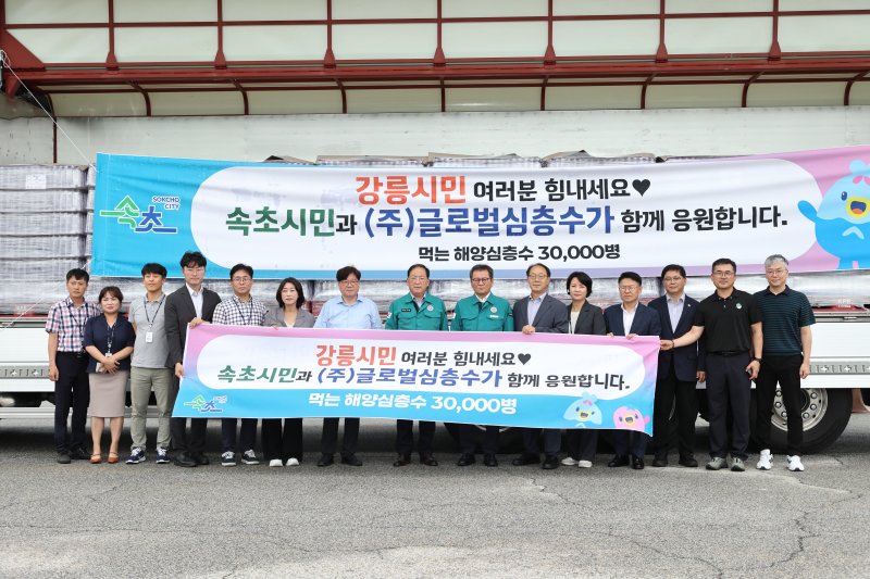 14일 김홍규 강릉시장과 이병선 속초시장, 김진규 글로벌심층수 대표, 두 지자체 간부공무원들이 속초시가 지원한 생수 앞에서 기념촬영을 하고 있다.(강릉시 제공, 재판매 및 DB 금지) 2025.8.14/뉴스1