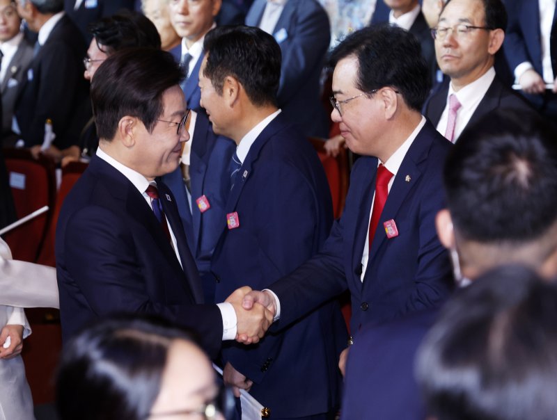 이재명 대통령이 15일 서울 세종문화회관에서 열린 80주년 광복절 경축식에서 국민의힘 송언석 비상대책위원장 겸 원내대표와 인사하고 있다. [대통령실통신사진기자단] 연합뉴스