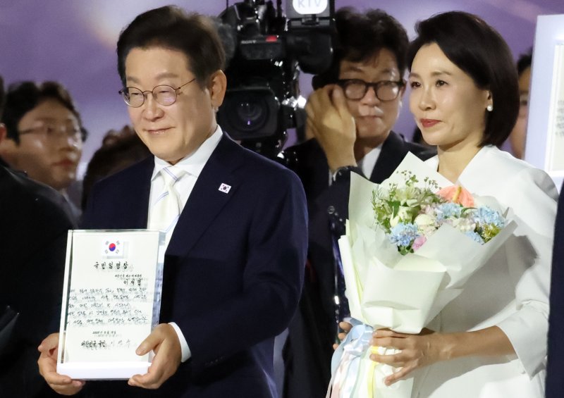 이재명 대통령이 15일 오후 서울 종로구 광화문광장에서 열린 '광복 80년, 국민 주권으로 미래를 세우다' 제21대 대통령 국민 임명식에서 국민 대표 80인이 참여한 임명장을 전달 받고 있다. 뉴스1