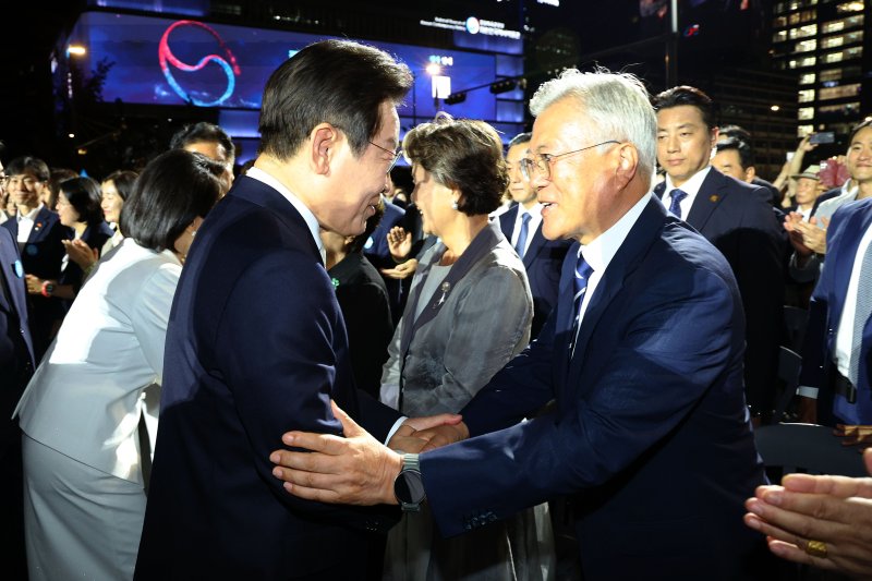 이재명 대통령이 15일 서울 세종대로 광화문광장에서 열린 제21대 대통령 국민임명식 '광복 80년, 국민주권으로 미래를 세우다' 행사에서 문재인 전 대통령과 인사하고 있다. 뉴시스