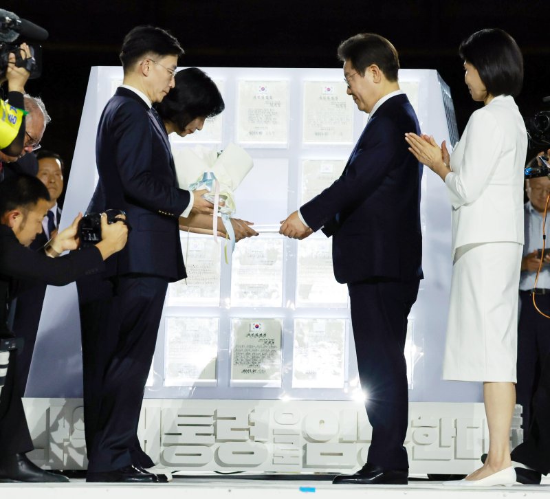 [서울=뉴시스] 고범준 기자 = 이재명 대통령이 15일 서울 세종대로 광화문광장에서 열린 제21대 대통령 국민임명식 '광복 80년, 국민주권으로 미래를 세우다' 행사에서 임명장을 받고 있다. 2025.08.15. bjko@newsis.com