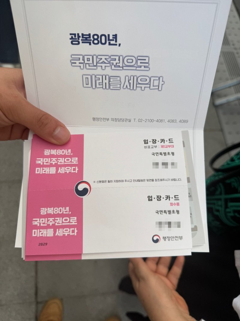 18일 오후 서울 광화문 광장에서 열린 제21대 대통령 국민임명식에 참석한 한 시민이 입장카드를 펼쳐 보이고 있다. 2025.8.15/뉴스1 권준언 기자