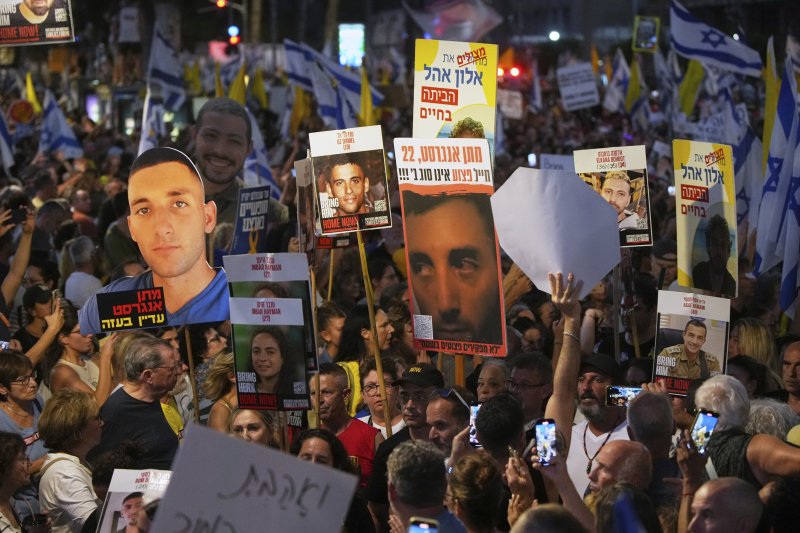 17일(현지시간) 이스라엘 텔아비브 도심에서 팔레스타인 가자지구 군사작전 확대에 반대하는 시위대가 억류된 인질들의 사진을 든 채 행진하고 있다.AP연합뉴스