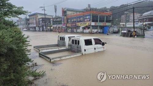 빗물에 잠긴 트럭 (출처=연합뉴스)