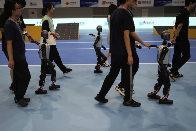 [베이징=AP/뉴시스] 16일(현지 시간) 중국 베이징 국가스피드스케이팅경기장에서 열린 2025 세계 휴머노이드 로봇 운동회에서 축구 경기를 마친 로봇들이 이동하고 있다. 2025.08.18.