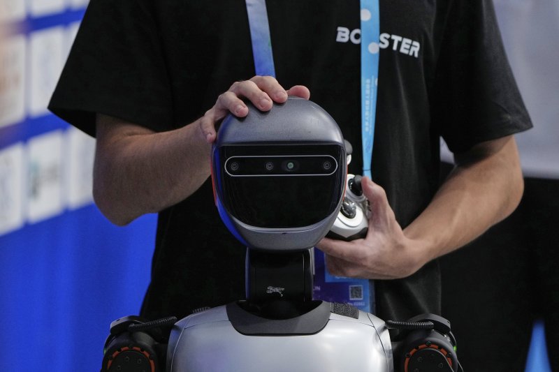 [베이징=AP/뉴시스] 16일(현지 시간) 중국 베이징 국가스피드스케이팅경기장에서 열린 2025 세계 휴머노이드 로봇 운동회에서 기술자가 로봇을 점검하고 있다. 2025.08.18.