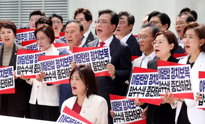 [서울=뉴시스] 추상철 기자 = 송언석 국민의힘 비상대책위원장 겸 원내대표를 비롯한 국민의힘 의원들이 18일 오후 서울 종로구 KT 광화문빌딩 웨스트에 마련된 김건희 여사 의혹을 수사하는 민중기 특별검사 사무실 앞에서 열린 '국민의힘 현장 비상의원총회-야당탄압 정치보복 압수수색 항의방문'에서 피켓을 들고 구호를 외치고 있다. 2025.08.18. scchoo@newsis.com