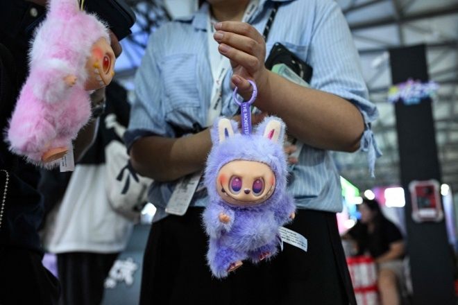 지난 4일 중국 상하이에서 열린 ‘중국 디지털 엔터테인먼트 엑스포 및 콘퍼런스’에서 한 여성이 방문객들에게 라부부 인형을 판매하고 있다. 기사와 직접적인 관련 없음. AFP 연합뉴스