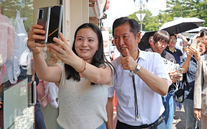 [경주=뉴시스] 이무열 기자 = 정청래 더불어민주당 대표가 20일 경북 경주시 황리단길을 찾아 시민과 기념촬영을 하고 있다. 2025.08.20. lmy@newsis.com