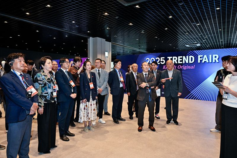 성래은 한국패션협회장(앞줄 왼쪽 네 번째)이 20일 서울 강남구 코엑스에서 열린 '2025 트렌드 페어' 행사장을 업계 관계자들과 둘러보고 있다. 한국패션협회 제공