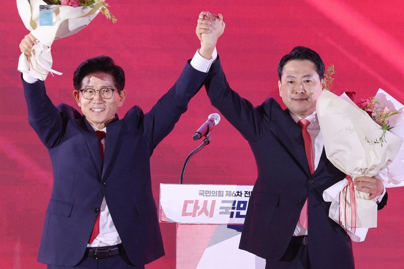 김문수(왼쪽)·장동혁 국민의힘 당대표 후보가 22일 오후 충북 청주시 오스코에서 열린 제6차 전당대회에서 결선 진출에 성공한 뒤 두 손을 번쩍 들어 기뻐하고 있다. 2028.8.22/뉴스1 ⓒ News1 신웅수 기자