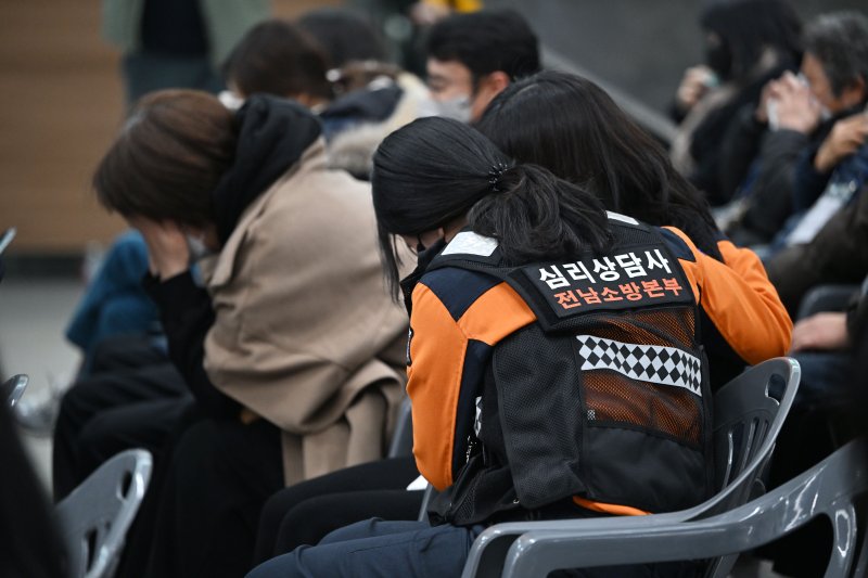 [무안=뉴시스] 이영주 기자 = 12·29 제주항공 여객기 참사 49일째를 맞는 15일 전남 무안군 무안국제공항에서 참사 49재 봉행에 참석하고 있는 한 유족이 전남소방본부 심리상담사로부터 위로받고 있다. 2025.02.15. leeyj2578@newsis.com