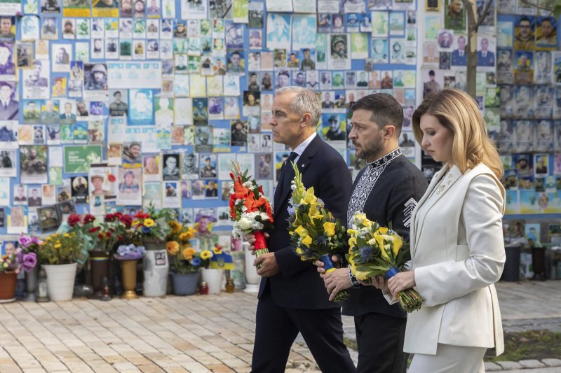 마크 카니 캐나다 총리(왼쪽)가 볼로디미르 젤렌스키 우크라이나 대통령 부부와 함께 24일(현지시간) 키이우에 있는 우크라이나 전사자 추모의 벽에서 헌화하고 있다.AP뉴시스