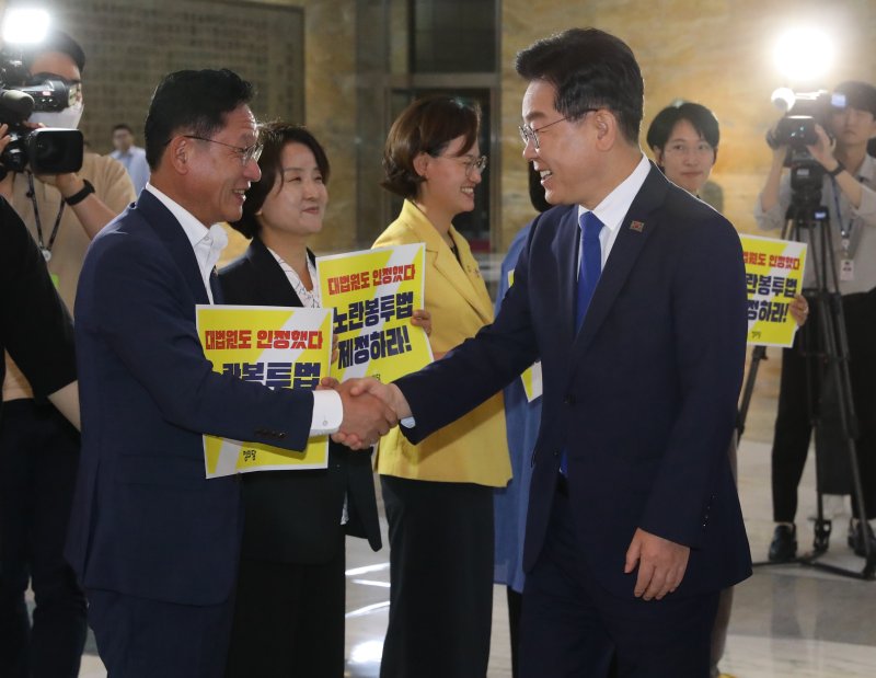 이재명 대통령이 더불어민주당 대표 시절이던 2023년, 서울 여의도 국회 로텐더홀에서 노란봉투법 처리 촉구 피케팅을 하고 있는 정의당 의원들과 인사하고 있다. 2023.6.19/뉴스1 ⓒ News1 송원영 기자