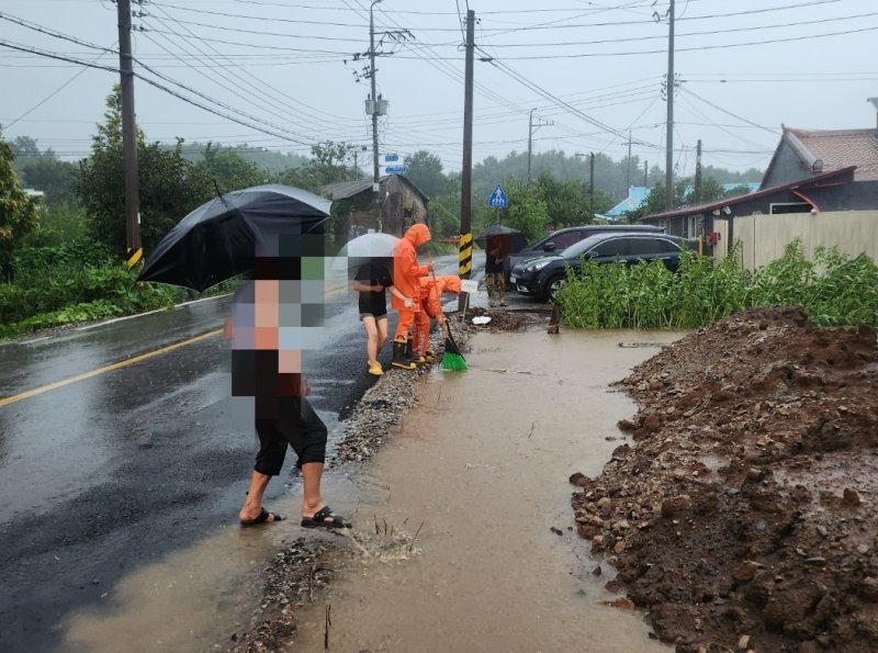 [군산=뉴시스] 26일 전북 군산시 회현면의 한 도로에서 호우로 인해 하수구가 막혀 물이 고이자 소방대원들이 조치에 나서고 있다. (사진=전북도소방본부 제공) 2025.08.26. photo@newsis.com *재판매 및 DB 금지 /사진=뉴시스