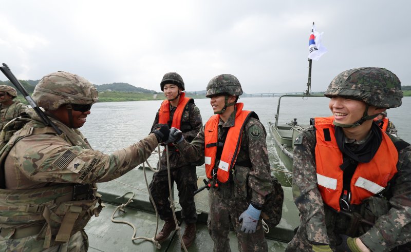 27일 경기 여주시 남한강 일대 훈련장에서 실시한 '한미연합 제병협동 도하훈련'에서 육군 제7공병여단 장병들과 미2사단/한미연합사단 장병들이 한미 합동 부교구축을 마친 뒤 서로를 격려하고 있다. 공동취재단