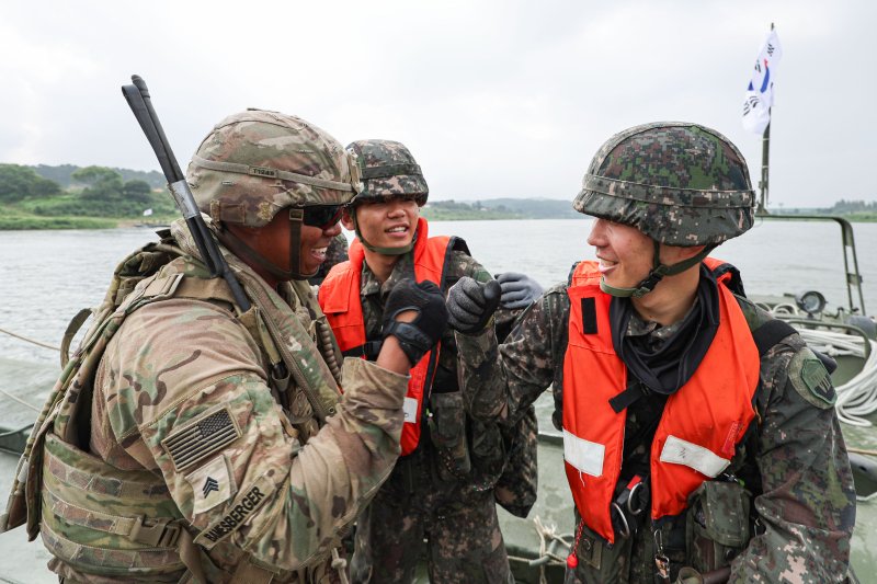 27일 경기 여주시 남한강 일대 훈련장에서 실시한 '한미연합 제병협동 도하훈련'에서 육군 제7공병여단 장병들과 미2사단/한미연합사단 장병들이 한미 합동 부교구축을 마친 뒤 서로를 격려하고 있다. 공동취재단