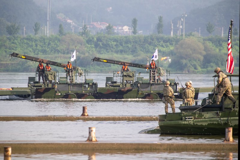 육군 제7공병여단은 2025년 UFS/TIGER의 일환으로 지난 25일부터 27일까지 경기도 여주 남한강 일대에서 '한미연합 제병협동 도하훈련'을 실시했다. 한미연합 도하작전능력을 제고하기 위해 실시된 이번 훈련에는 한미 장병 300여 명과 한측 자주도하장비 수룡, 미측 스트라이커 장갑차 등 총 130여 대의 장비가 투입되었다. 사진은 자주도하장비 수룡과(왼쪽, 중앙) 미군의 교량가설단정이 도하작전을 실시하기 위해 물 위로 전개하고 있는 모습. 육군 제공