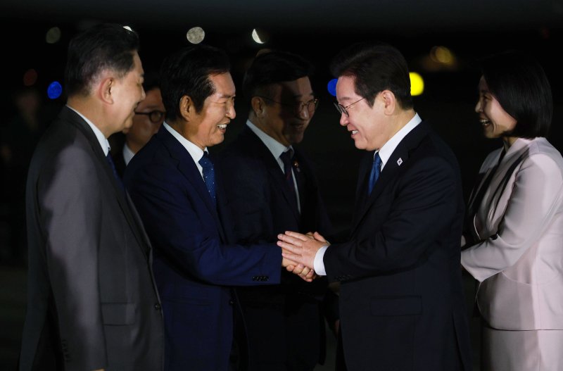 일본·미국 순방 일정을 마치고 귀국한 이재명 대통령이 28일 경기 성남 서울공항에서 정청래 더불어민주당 대표와 악수하고 있다. 뉴시스