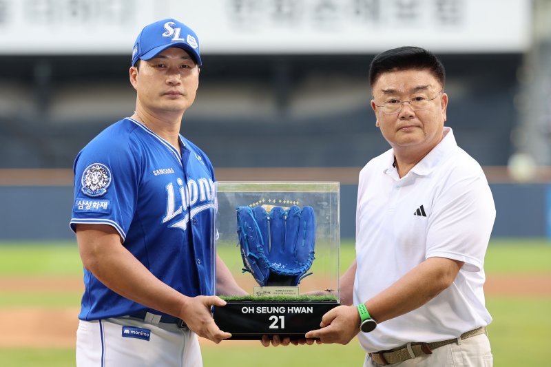 [서울=뉴시스] 권창회 기자 = 28일 서울 송파구 잠실야구장에서 KBO리그 두산 베어스와 삼성라이온즈의 경기 시작에 앞서 열린 오승환 은퇴투어 기념행사에서 삼성 오승환이 김태룡 두산베어스 단장으로부터 야구글러브를 전달받고 있다. 2025.08.28. kch0523@newsis.com