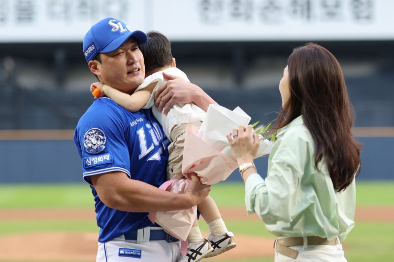 [서울=뉴시스] 권창회 기자 = 28일 서울 송파구 잠실야구장에서 KBO리그 두산 베어스와 삼성라이온즈의 경기 시작에 앞서 열린 오승환 은퇴투어 기념행사에서 삼성 오승환이 가족들로부터 꽃다발을 받고 있다. 2025.08.28. kch0523@newsis.com