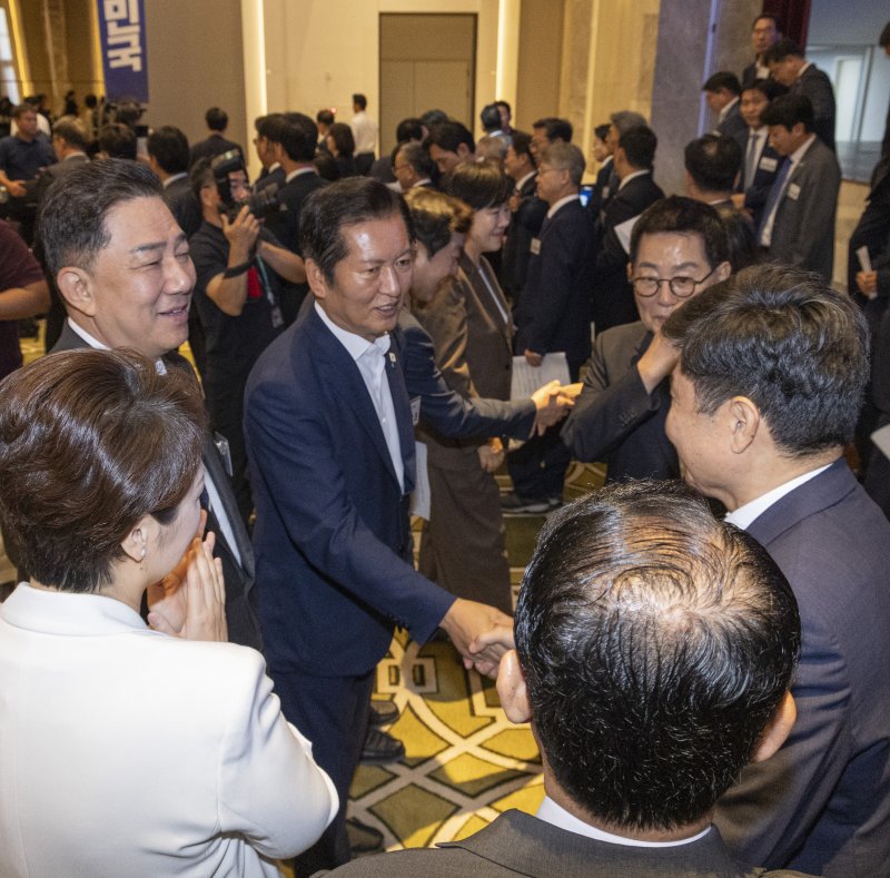 더불어민주당 정청래 대표와 김병기 원내대표가 29일 인천시 중구 파라다이스시티 컨벤션에서 열린 2025 정기국회 더불어민주당 의원단 워크숍에서 결의문을 채택한 뒤 동료 의원들과 악수하고 있다. 연합뉴스