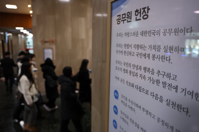 [서울=뉴시스] 배훈식 기자 = 지난 2월 3일 오후 서울 종로구 정부서울청사 로비에 걸린 공무원 헌장 아래로 공무원들이 걸어가고 있다. 2025.02.03. dahora83@newsis.com