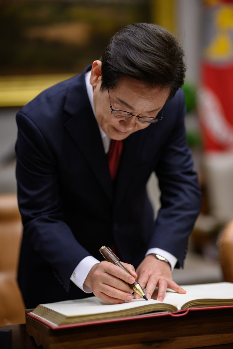 지난 8월 25일(현지시간) 이재명 대통령이 도널드 트럼프 대통령과의 정상회담에 앞서 미 백악관 루즈벨트룸에서 방명록에 서명하고 있다. 백악관 제공