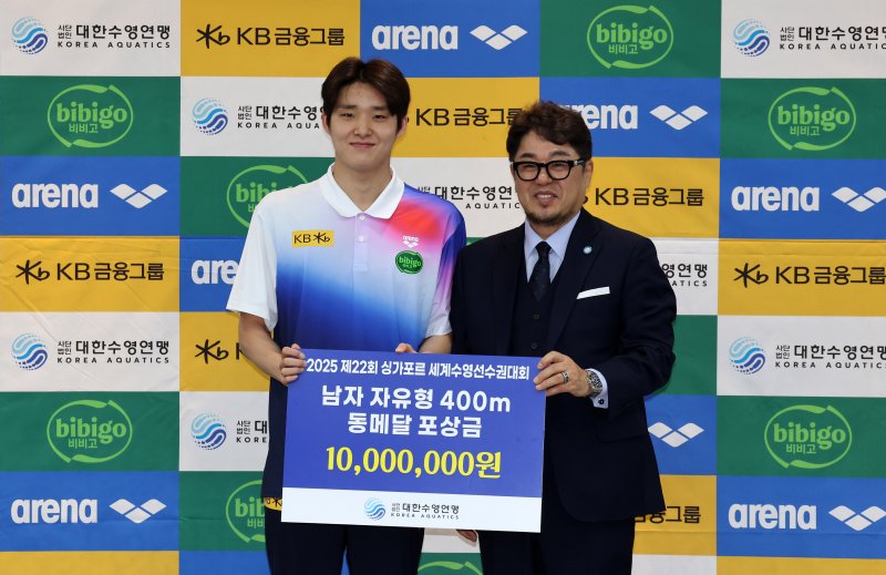 [서울=뉴시스] 배훈식 기자 = 정창훈(오른쪽) 대한수영연맹 회장이 1일 오전 서울 송파구 서울올림픽파크텔에서 열린 2025 제22회 싱가포르 세계수영선수권대회 수영 국가대표선수단 포상식에서 김우민(강원도청)에게 동메달 포상금 1000만원을 전달한 뒤 기념촬영을 하고 있다. 2025.09.01. dahora83@newsis.com