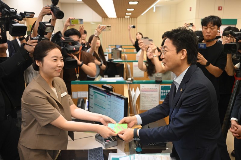 권대영 금융위원회 부위원장이 1일 오전 서울 중구 하나은행 본점에서 열린 예금보호한도 1억원 시행 현장방문에서 예금상품 가입을 마친 뒤 직원으로부터 통장을 수령하고 있다. (공동취재) 2025.9.1/뉴스1 ⓒ News1 이광호 기자